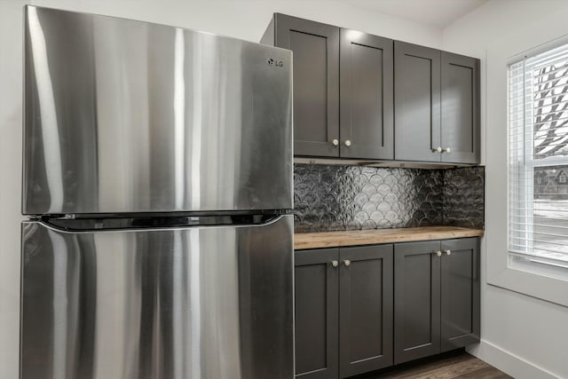 kitchen featuring tasteful backsplash, wood counters, stainless steel refrigerator, dark hardwood / wood-style flooring, and gray cabinets