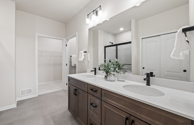 bathroom with a shower with shower door and vanity