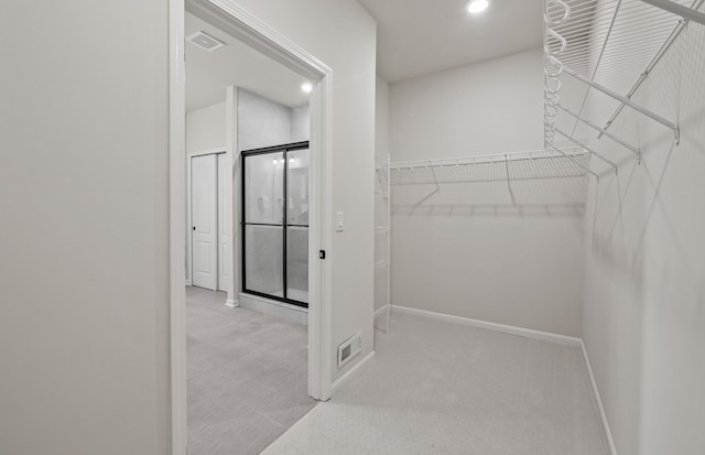 walk in closet featuring light carpet