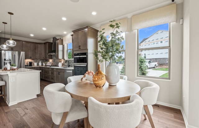 dining room with light hardwood / wood-style floors and sink