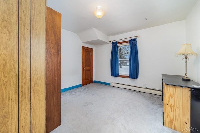 bonus room with light carpet and baseboard heating