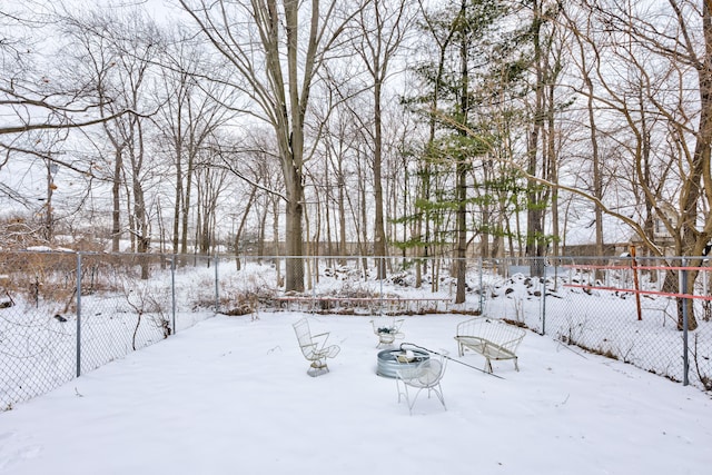 snowy yard featuring a fenced backyard