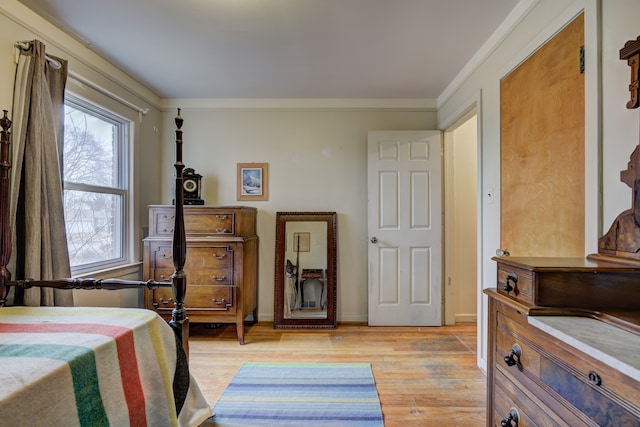 bedroom featuring light wood-style floors, crown molding, and baseboards