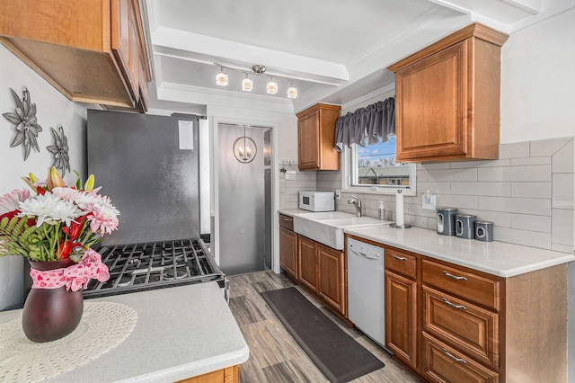 kitchen featuring sink, light hardwood / wood-style floors, white appliances, and decorative backsplash