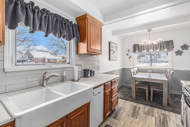 kitchen with decorative light fixtures, a healthy amount of sunlight, dishwasher, and sink