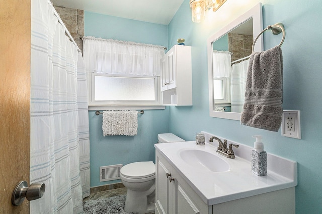 bathroom featuring toilet, vanity, and walk in shower