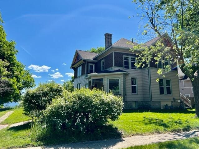 view of side of home with a yard