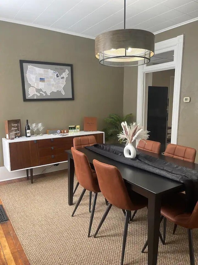 dining space featuring hardwood / wood-style flooring and ornamental molding