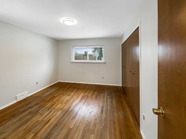 29743 Chelmsford Rd, Southfield, MI 48076 - unfurnished bedroom featuring dark wood-style flooring, visible vents, and baseboards