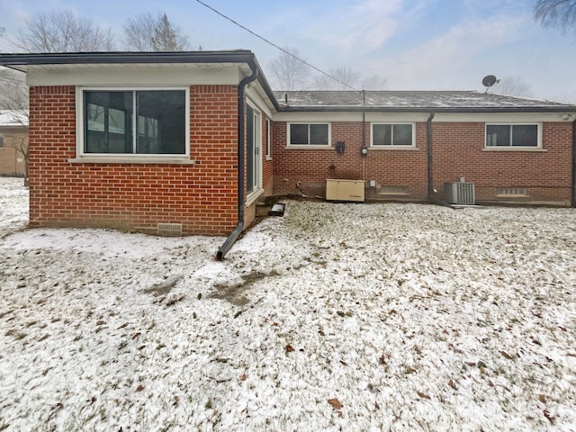29743 Chelmsford Rd, Southfield, MI 48076 - snow covered rear of property with cooling unit, crawl space, and brick siding