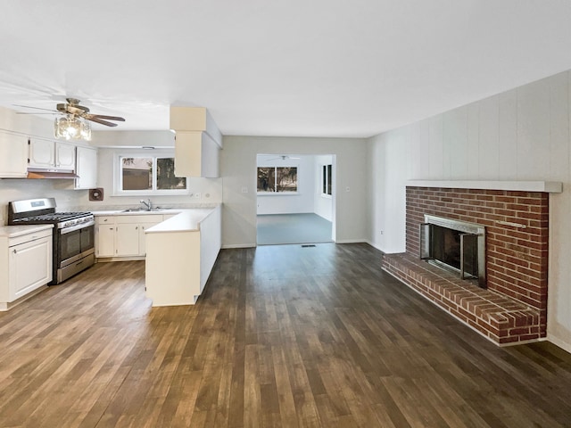 29743 Chelmsford Rd, Southfield, MI 48076 - kitchen featuring a sink, open floor plan, light countertops, a brick fireplace, and stainless steel range with gas cooktop