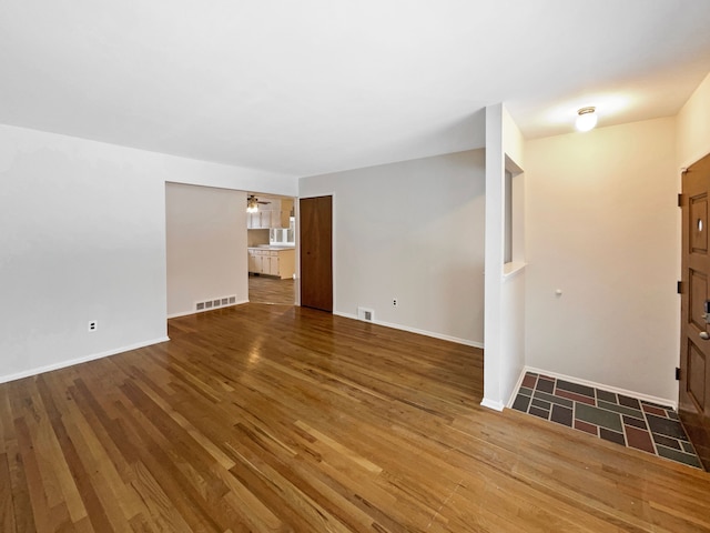 29743 Chelmsford Rd, Southfield, MI 48076 - unfurnished living room featuring ceiling fan, wood finished floors, visible vents, and baseboards