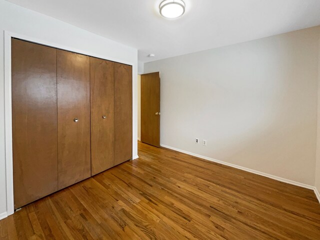 29743 Chelmsford Rd, Southfield, MI 48076 - unfurnished bedroom with a closet, baseboards, and wood finished floors