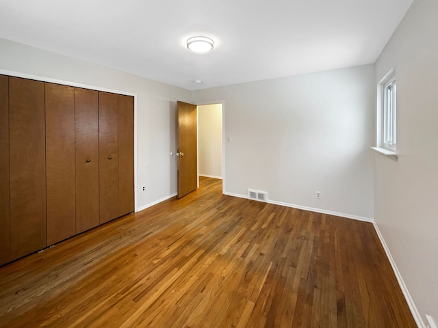 29743 Chelmsford Rd, Southfield, MI 48076 - unfurnished bedroom featuring hardwood / wood-style flooring, a closet, visible vents, and baseboards
