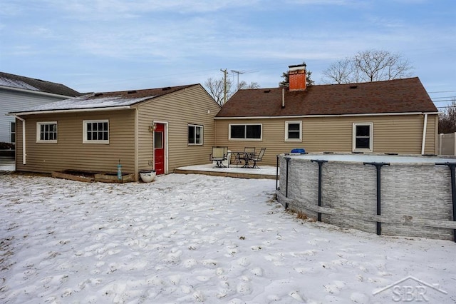 view of snow covered rear of property