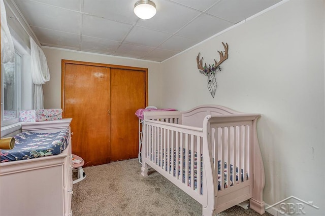 bedroom featuring carpet and a nursery area