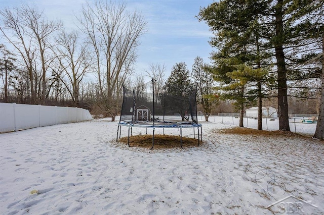 yard covered in snow with a trampoline