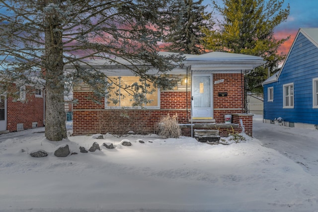 view of front of house featuring entry steps and brick siding