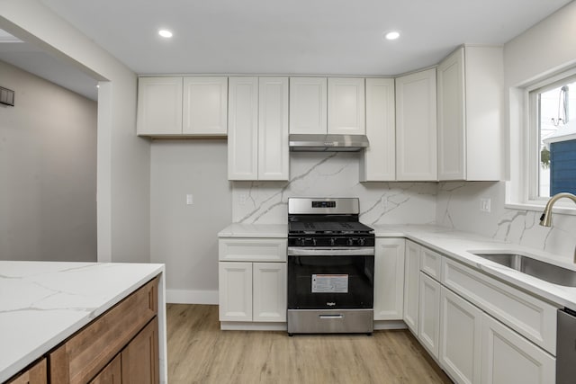 kitchen with appliances with stainless steel finishes, sink, light stone countertops, and white cabinets