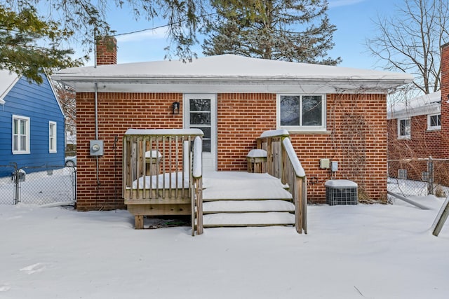 snow covered rear of property featuring cooling unit