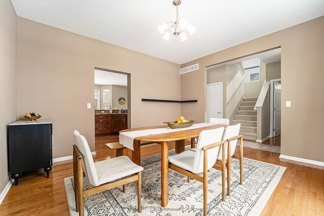 dining space with a chandelier and light hardwood / wood-style flooring