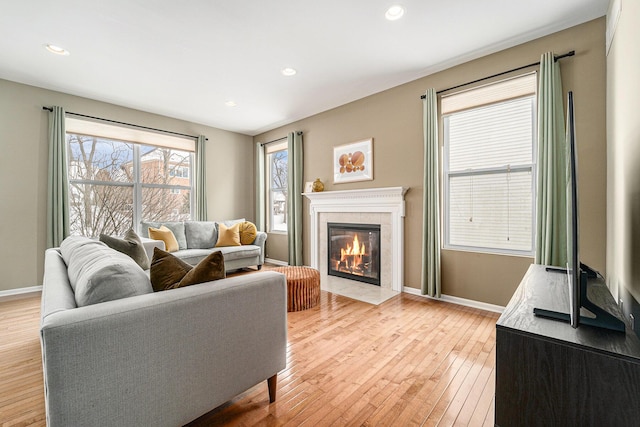 living room with a tiled fireplace and light hardwood / wood-style floors