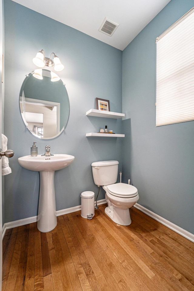 bathroom featuring toilet and wood-type flooring