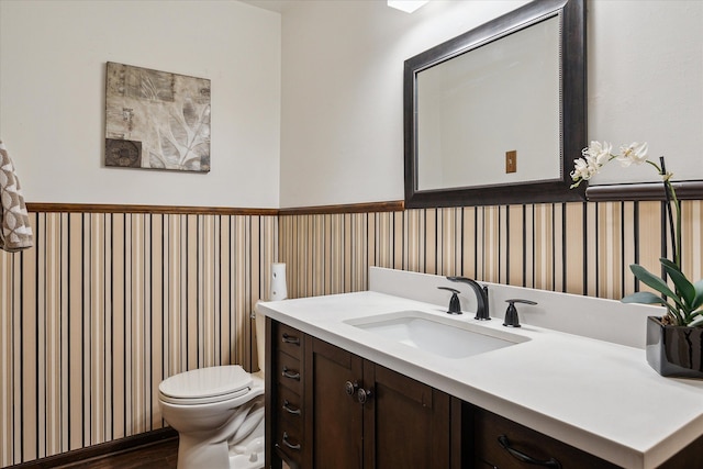 bathroom with hardwood / wood-style flooring, vanity, and toilet