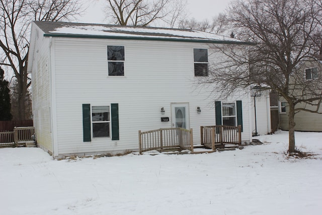 view of snow covered back of property