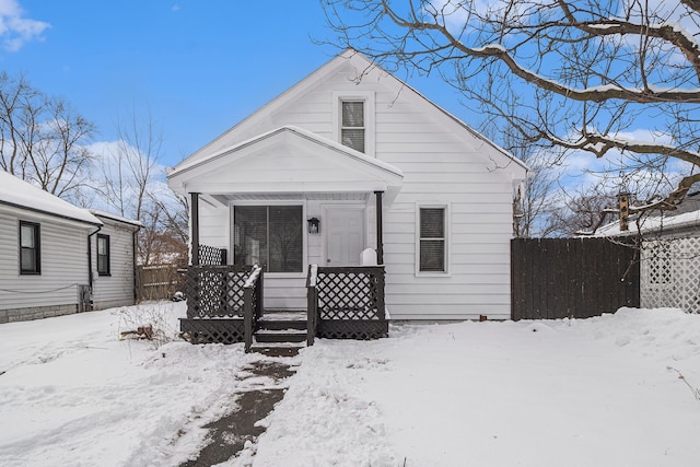 bungalow-style house with a porch and fence