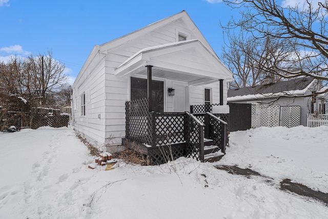 view of front of house with a garage, a porch, and fence