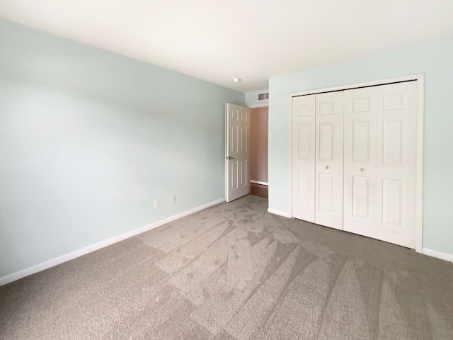 unfurnished bedroom with carpet floors and a closet