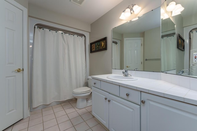 bathroom featuring toilet, vanity, and tile patterned flooring