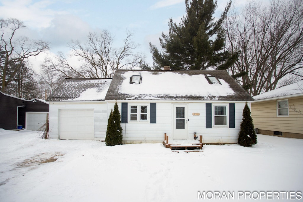 snow covered property featuring a garage