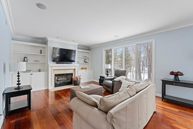 living room featuring a fireplace, ornamental molding, and wood-type flooring