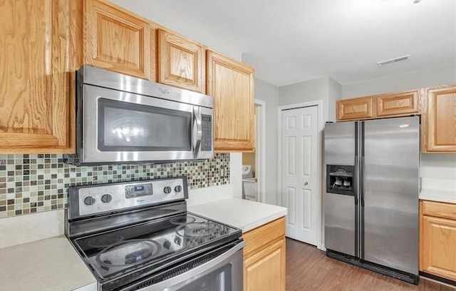 kitchen featuring light countertops, appliances with stainless steel finishes, and light brown cabinetry