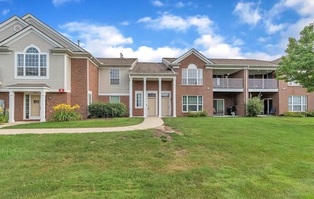 view of front of home with a front lawn and brick siding