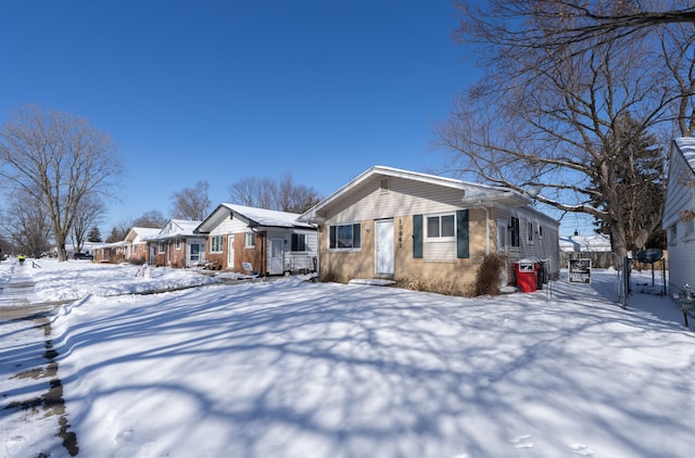 view of front of house featuring brick siding and fence