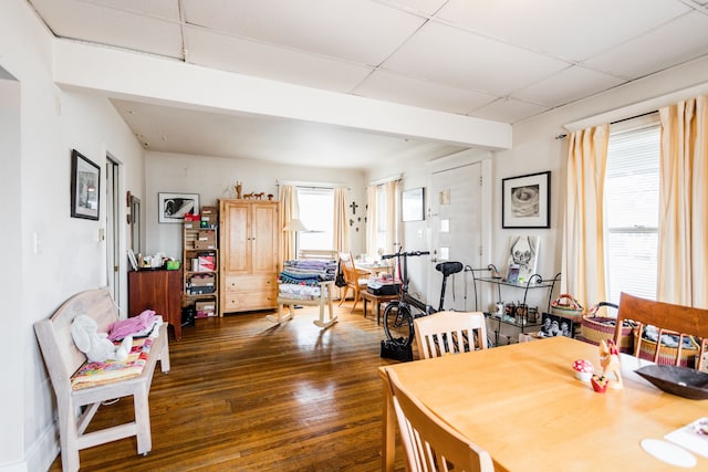 dining space with a paneled ceiling and dark wood-style flooring