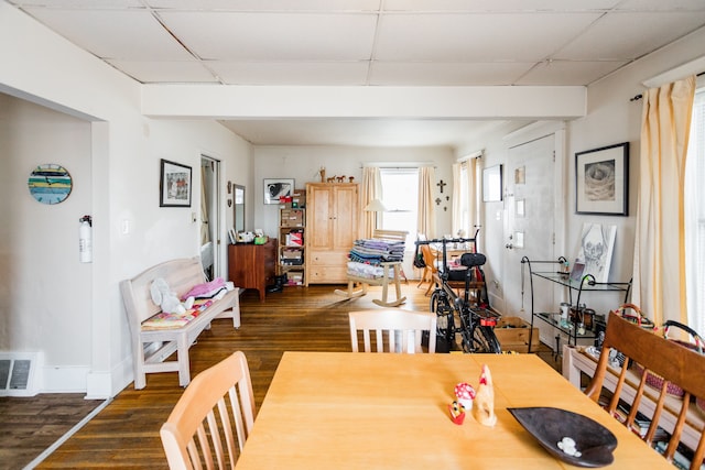 dining space featuring a drop ceiling, dark wood finished floors, visible vents, and baseboards