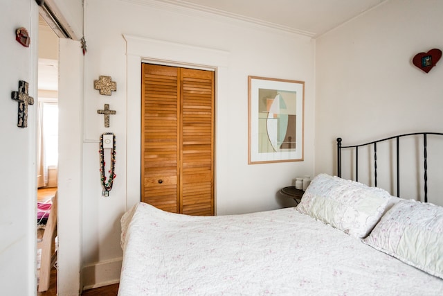 bedroom with ornamental molding and a closet