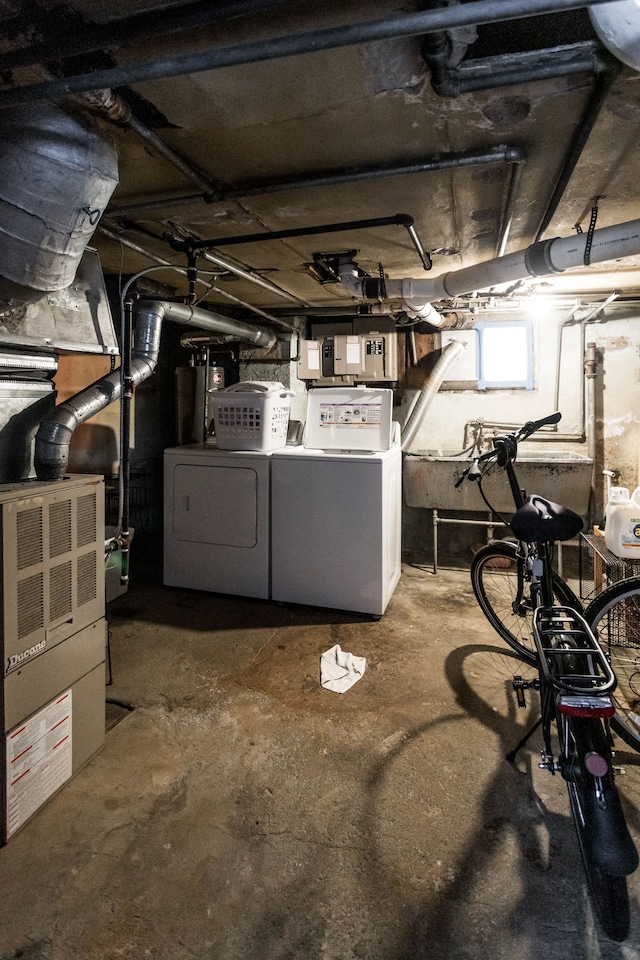 basement with washing machine and clothes dryer and heating unit