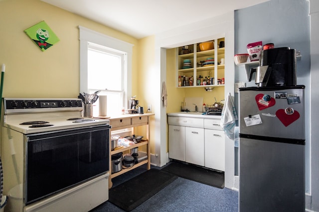 kitchen featuring a sink, white cabinetry, light countertops, freestanding refrigerator, and white electric range oven