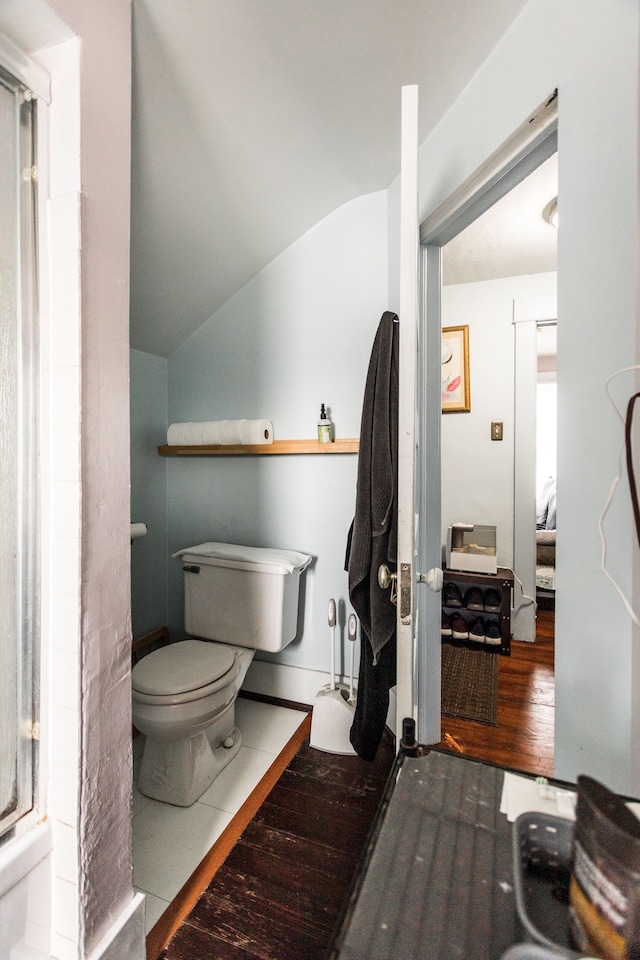 bathroom featuring toilet, vaulted ceiling, and wood finished floors