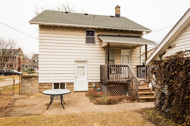 rear view of property with a patio area, a shingled roof, a chimney, and fence