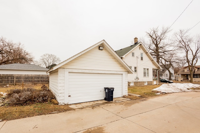 view of home's exterior featuring a garage, fence, and an outdoor structure