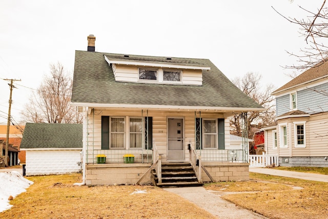 bungalow-style house with covered porch, a chimney, and roof with shingles