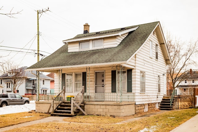 bungalow-style home featuring a shingled roof, a chimney, and a porch