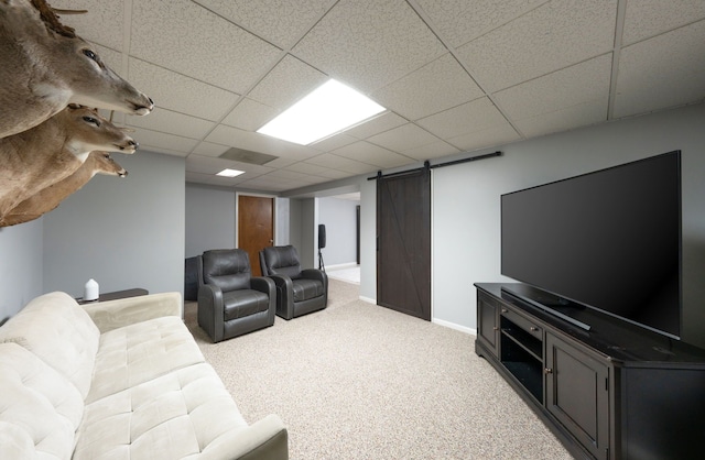 living room featuring visible vents, a barn door, light carpet, a drop ceiling, and baseboards