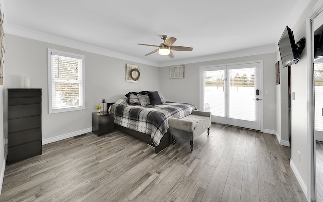 bedroom featuring ornamental molding, multiple windows, light wood-type flooring, and access to exterior